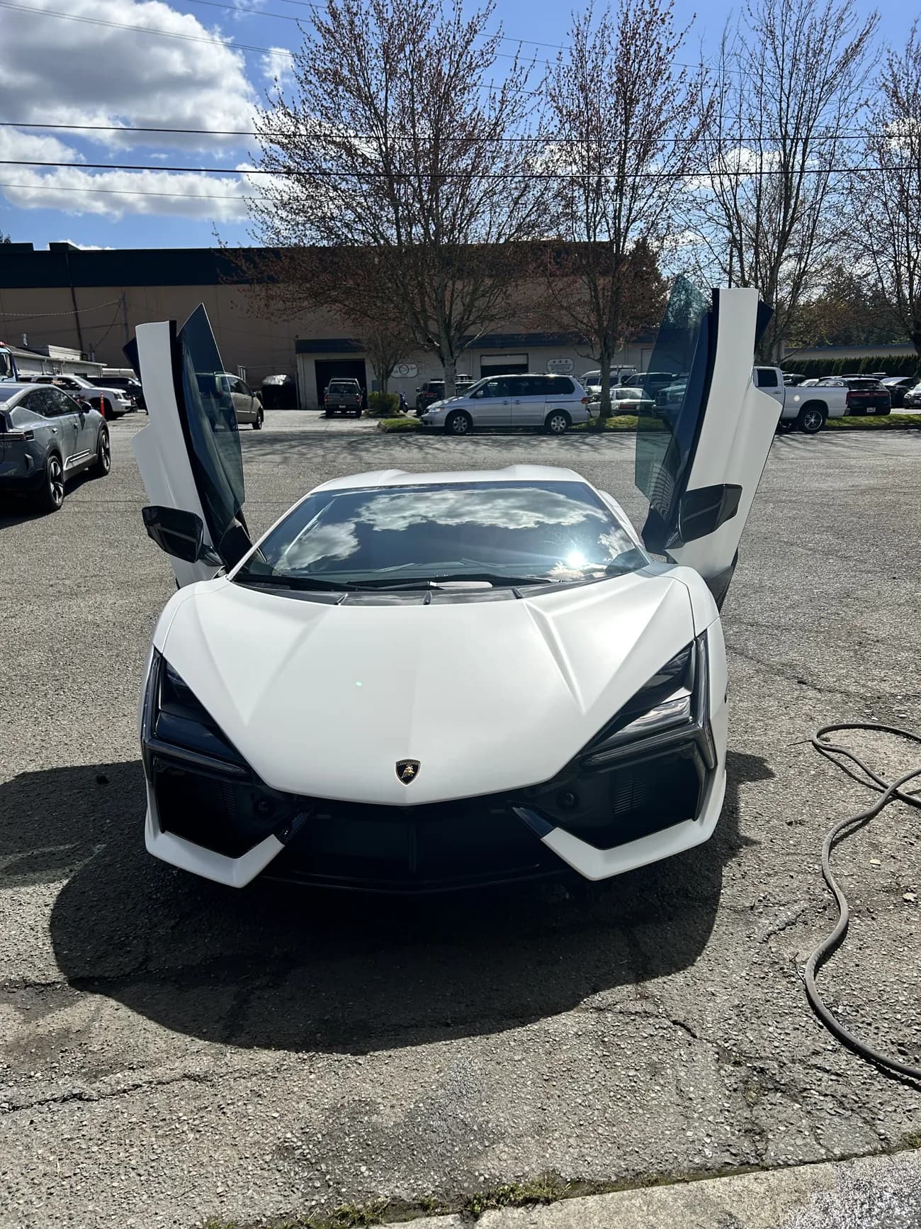 White Lamborghini Revuelto with a door raised.
